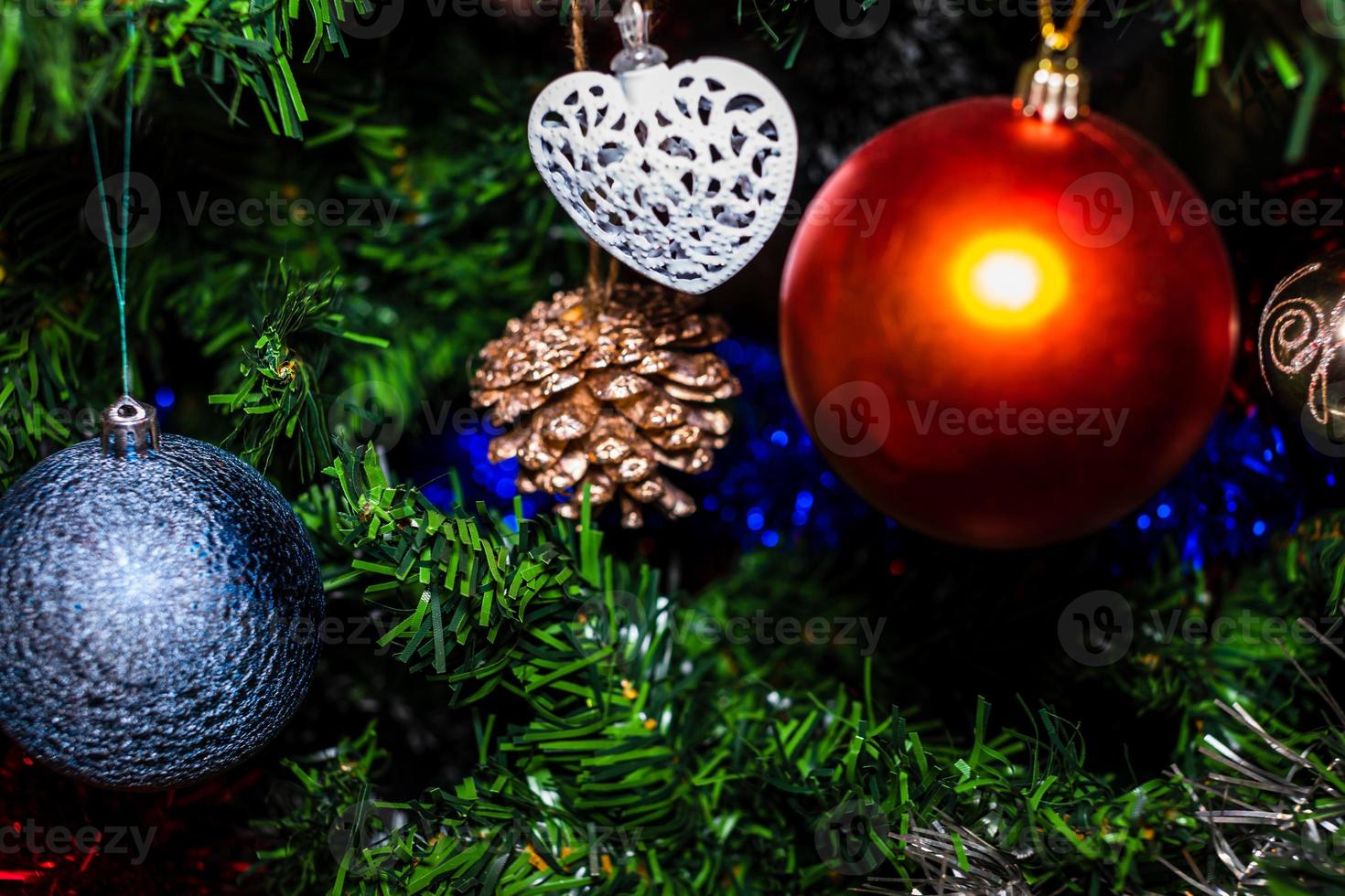 enfeites de natal pendurados em pinheiro foto