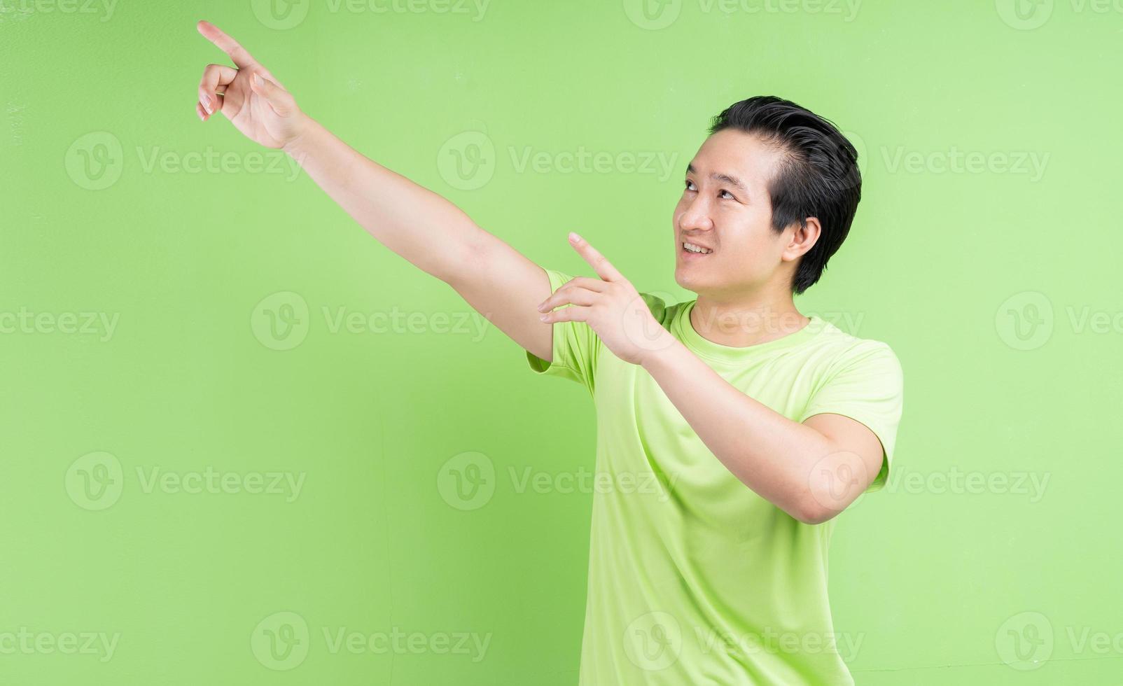 retrato de homem asiático em camiseta verde, posando sobre fundo verde foto