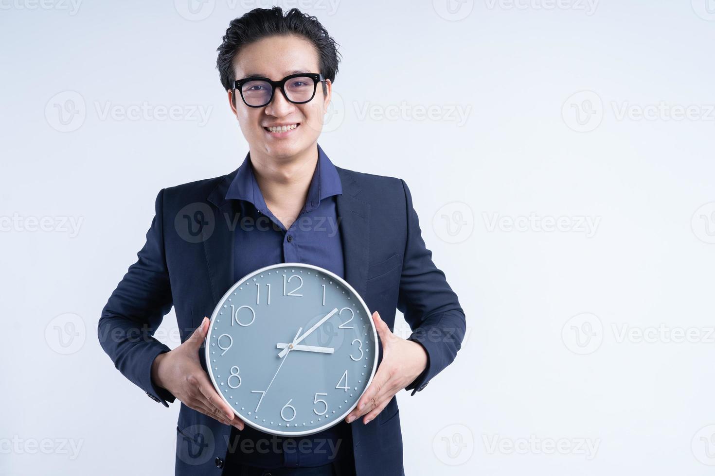 retrato de empresário asiático segurando o relógio foto