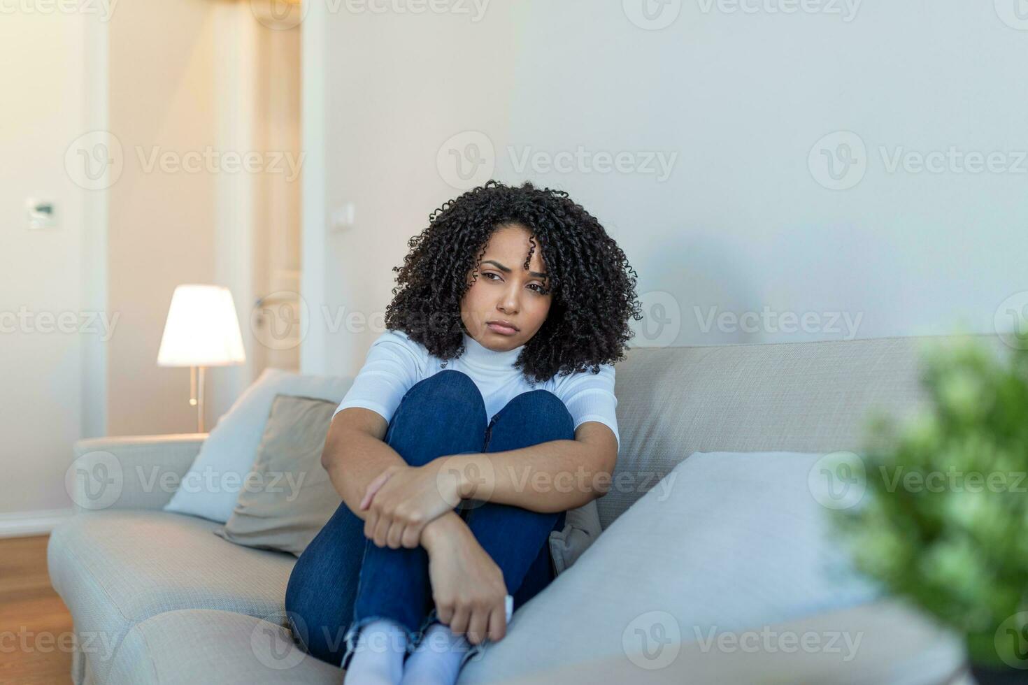 jovem africano americano mulher sentindo-me chateado, triste, infeliz ou decepcionar chorando solitário dentro dela sala. mulher sofrimento a partir de depressão sentado em cama e chorando foto
