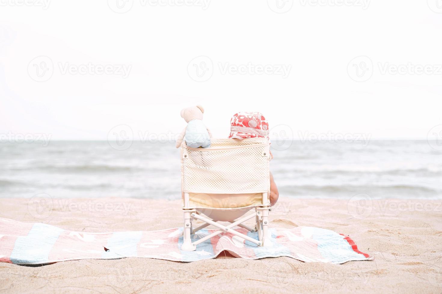 bebê sentado na praia em um lindo dia de verão. foto