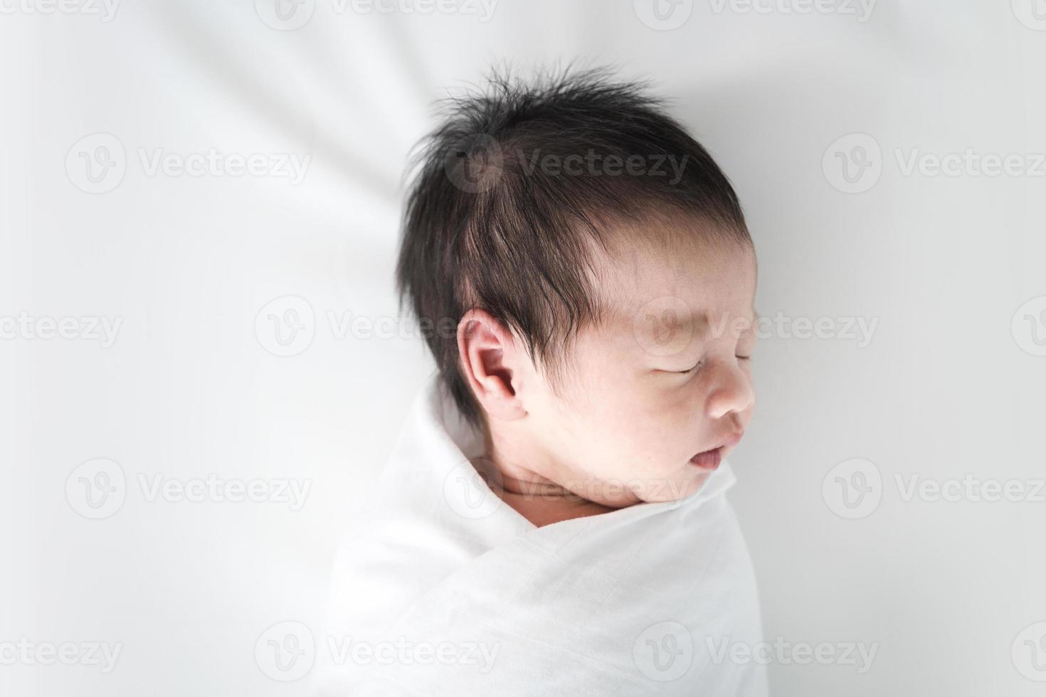 bebê recém-nascido dormindo no cobertor branco. foto