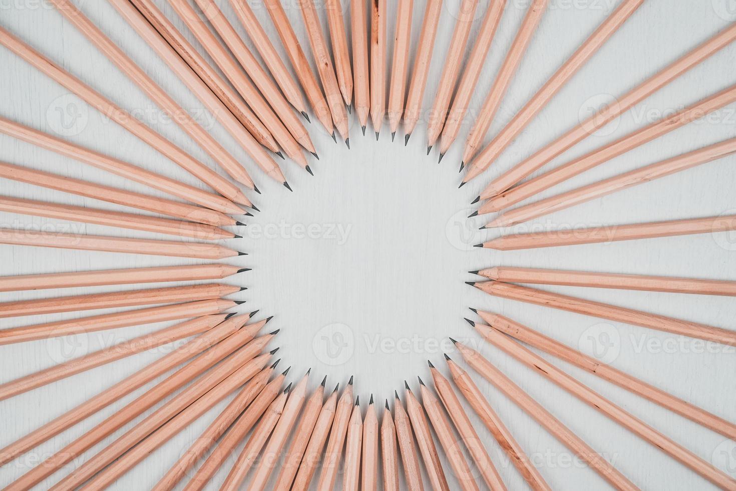 lápis de madeira dispostos em um círculo na mesa branca. foto