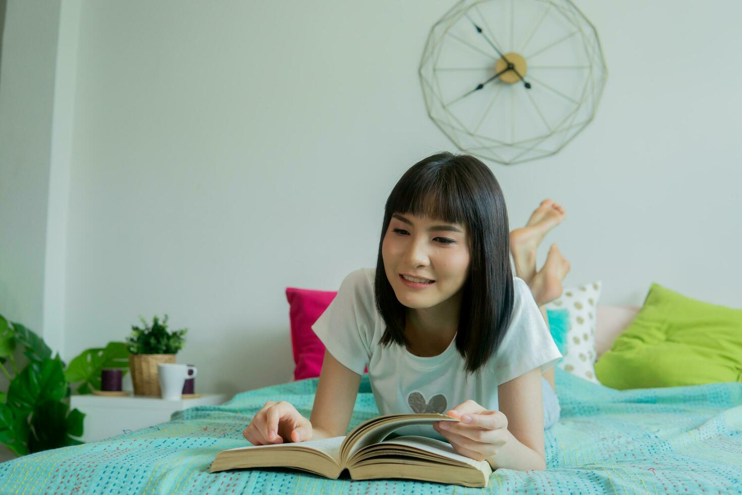 jovem mulher lendo livro com cachorro em cama às lar. foto