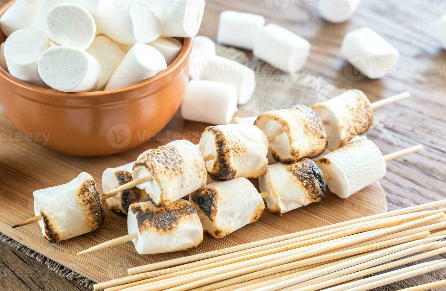 espetos de marshmallow na placa de madeira foto