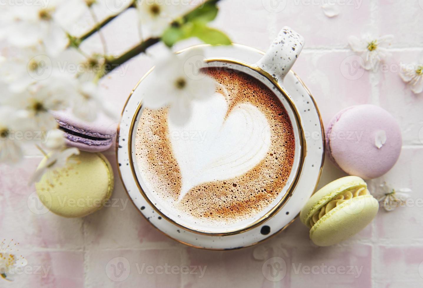 café com formato de coração e sobremesas doces de macaroons foto