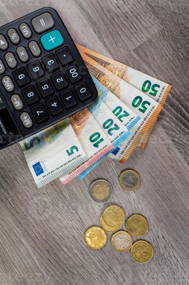 dinheiro em euros de diferentes denominações e calculadora foto