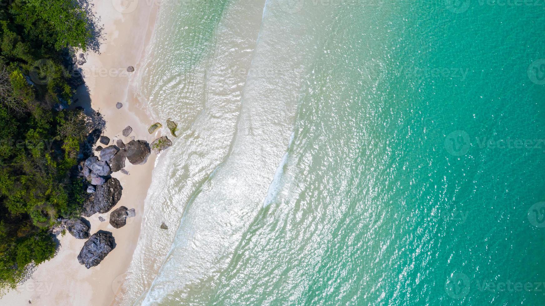 vista aérea da praia com sombra azul esmeralda água e ondas de espuma no mar tropical foto
