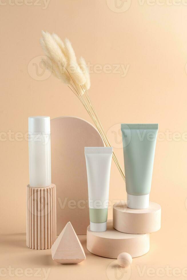 grupo do branco e verde em branco, sem marca Cosmético creme tubos e toner garrafa em bege fundo. pele Cuidado produtos apresentação. elegante brincar. cuidados com a pele, beleza e spa. jarra, tubo com cópia de espaço foto