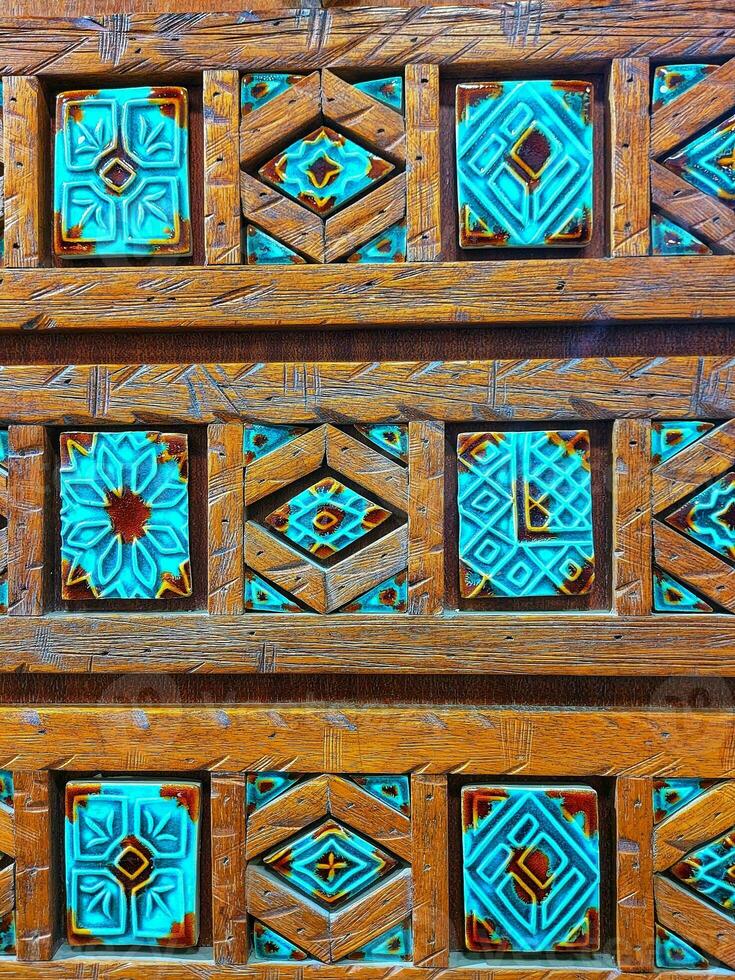 de madeira artesanato Projeto , tradicional madeira teto do velho edifício, estampado feito à mão geométrico étnico árabe azulejos, fechar acima ornamentado árabe de madeira parede, decorado de madeira texturizado fundo foto