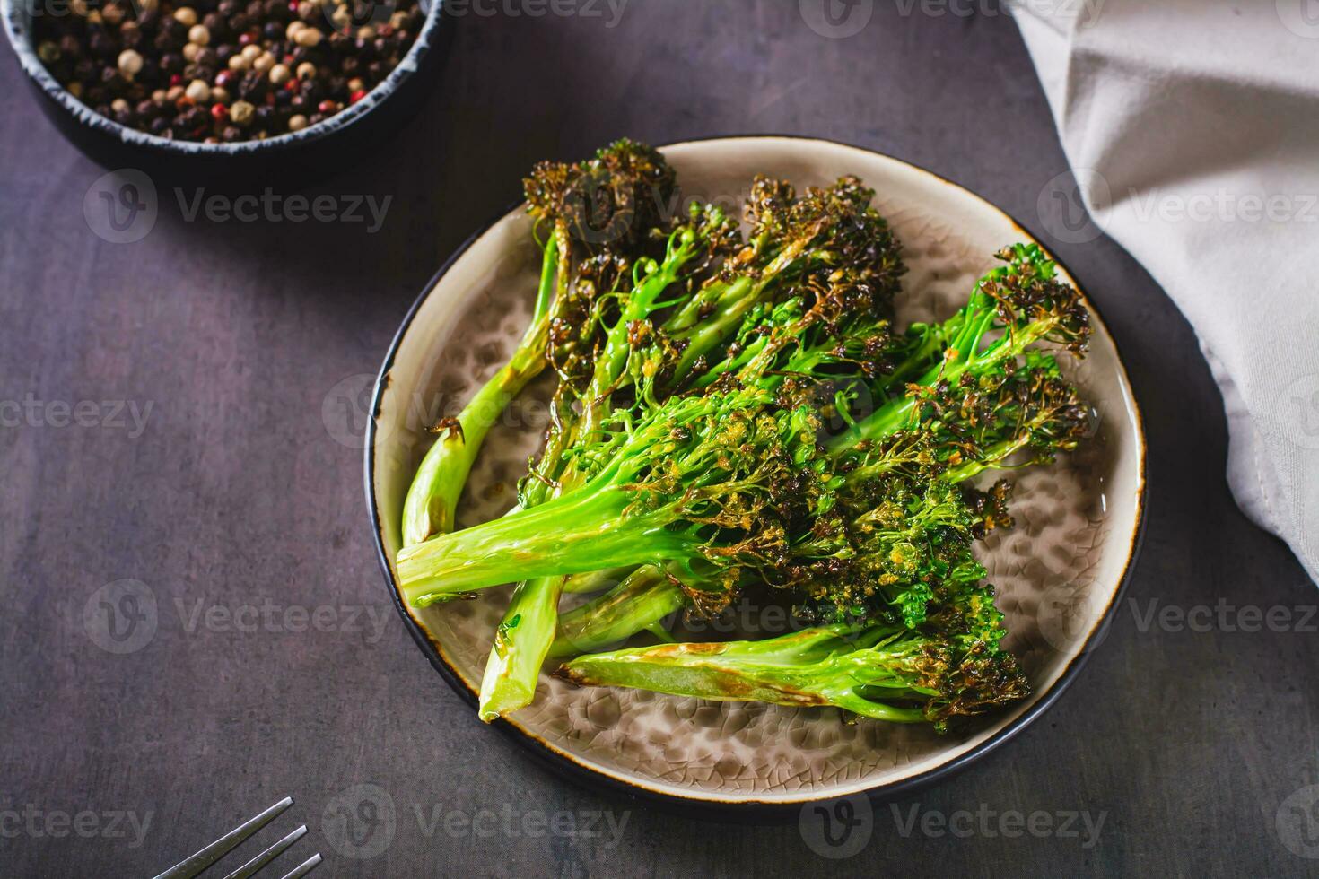 assado fresco brócolis brotos dentro óleo em uma prato em a mesa foto