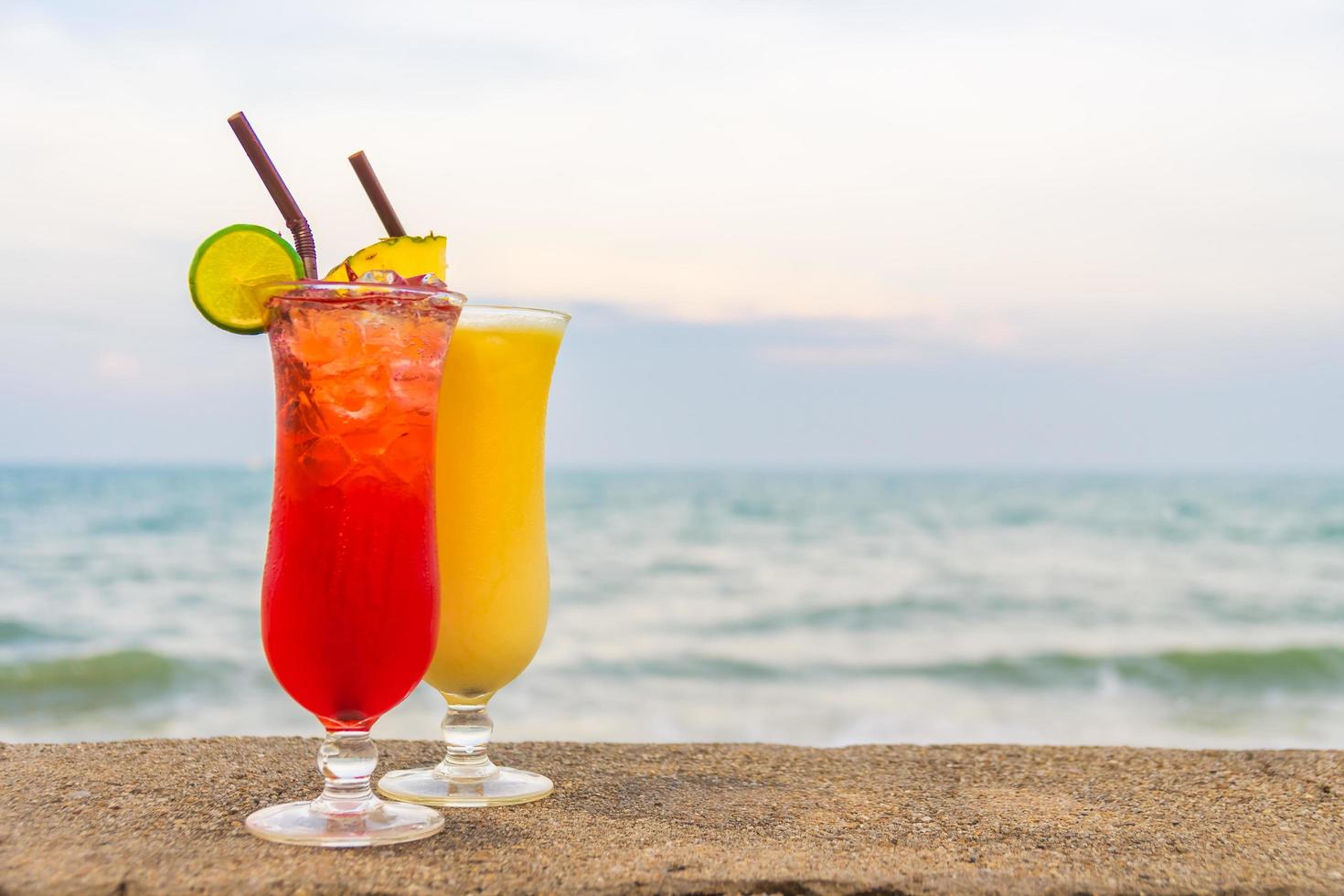 coquetéis gelados bebendo copo com mar e praia foto