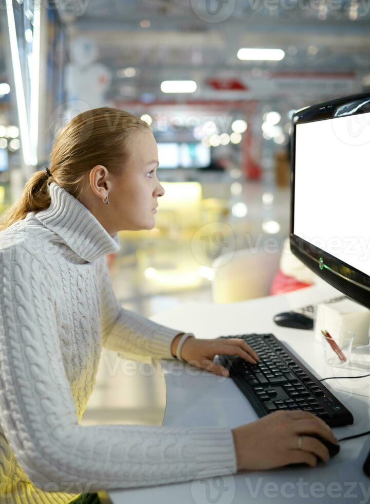 jovem menina e em branco monitor. foto