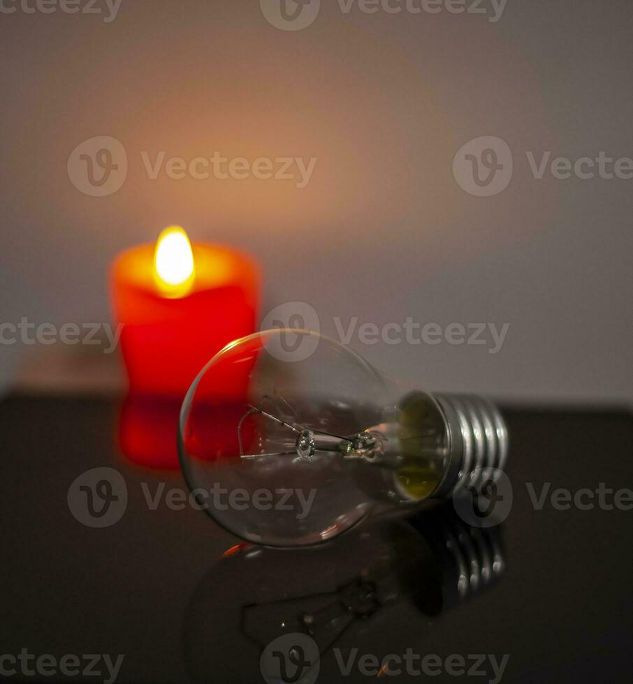 queimando vela perto uma comutado fora luz lâmpada dentro completo escuridão. queda de energia, eletricidade desligado, energia crise ou poder interrupção, conceito imagem foto