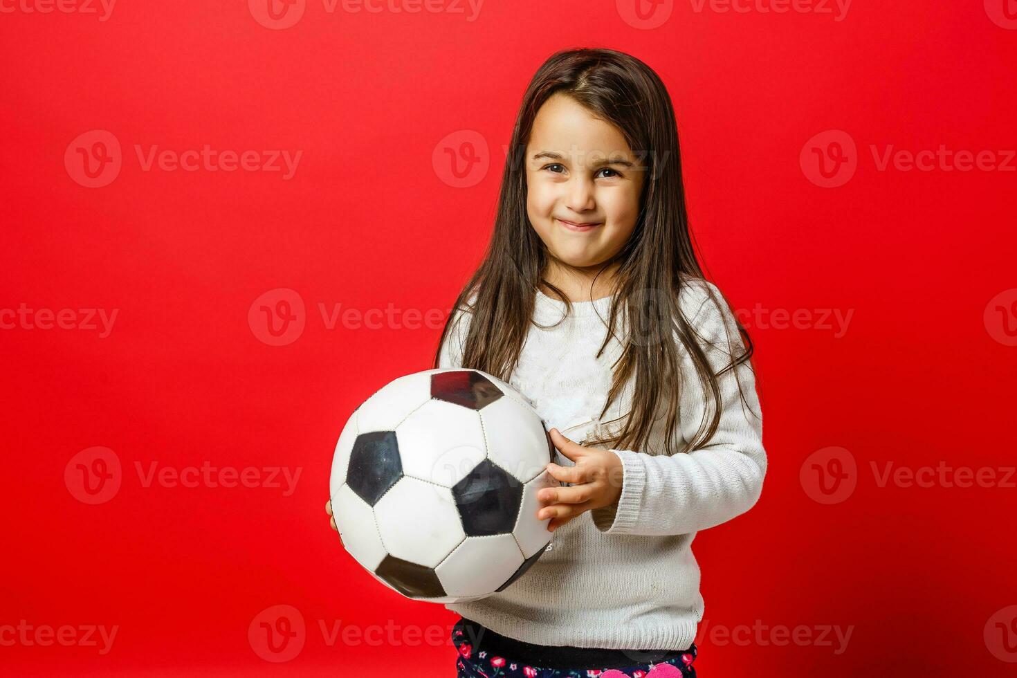 feliz pequeno menina sorrisos com futebol bola dentro mãos foto