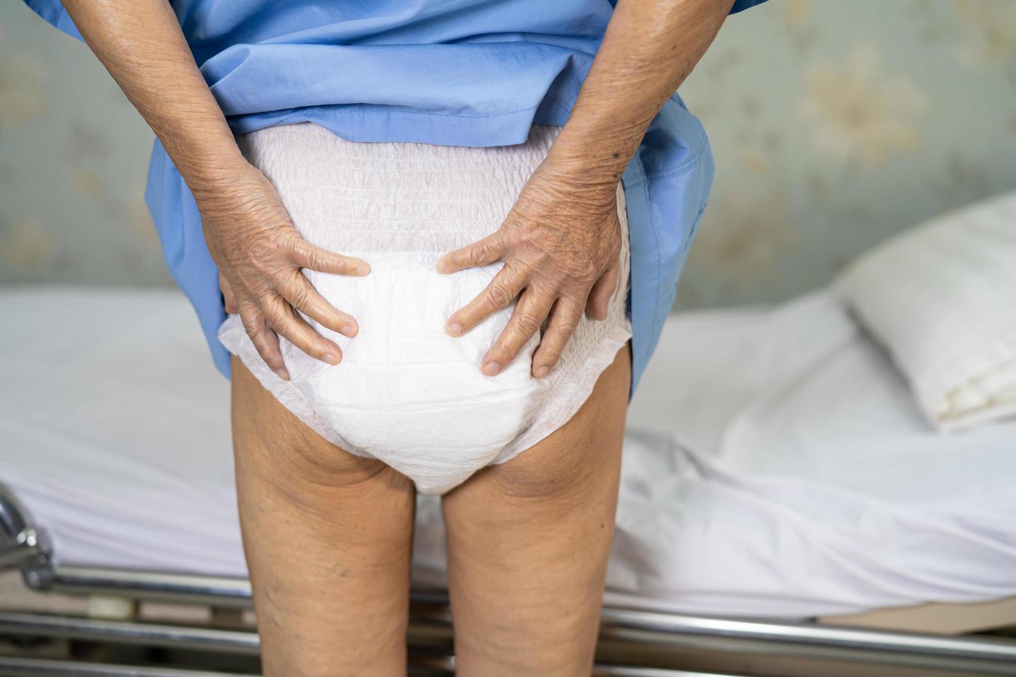 paciente asiático sênior ou idosa senhora idosa usando fralda para incontinência na enfermaria do hospital, conceito médico forte e saudável. foto