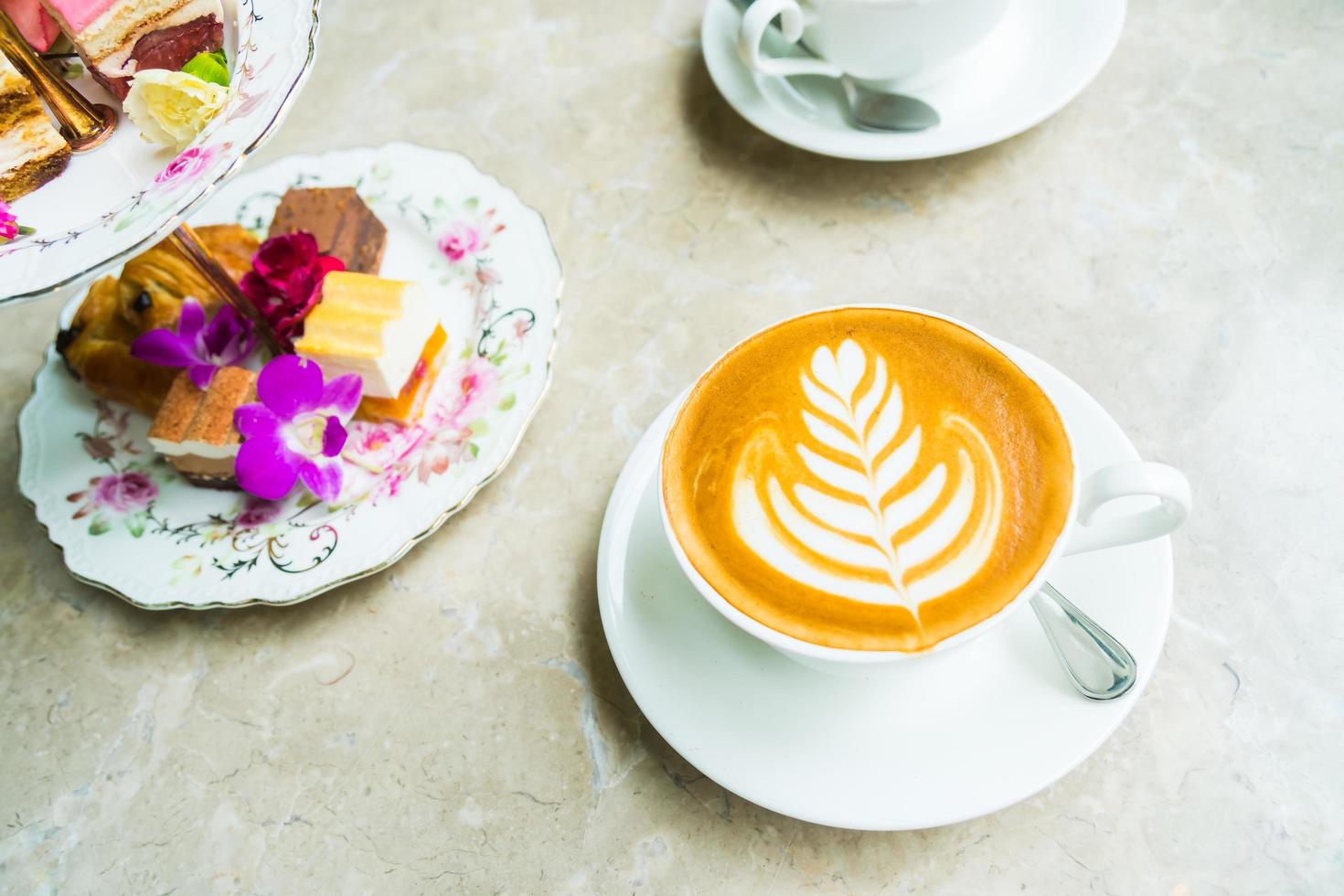 xícara branca com café com leite e bolo foto