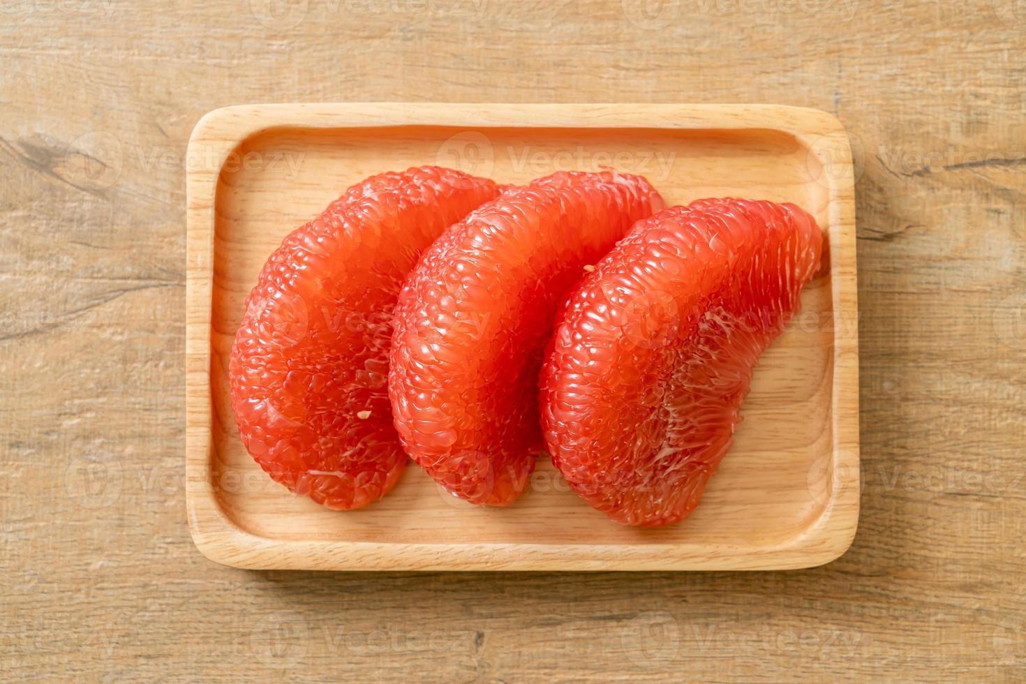 pomelo vermelho fresco ou toranja no prato foto