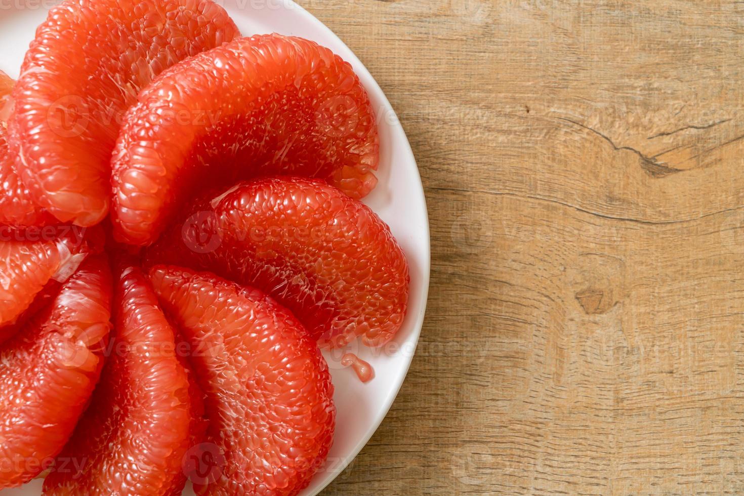 pomelo vermelho fresco ou toranja no prato foto