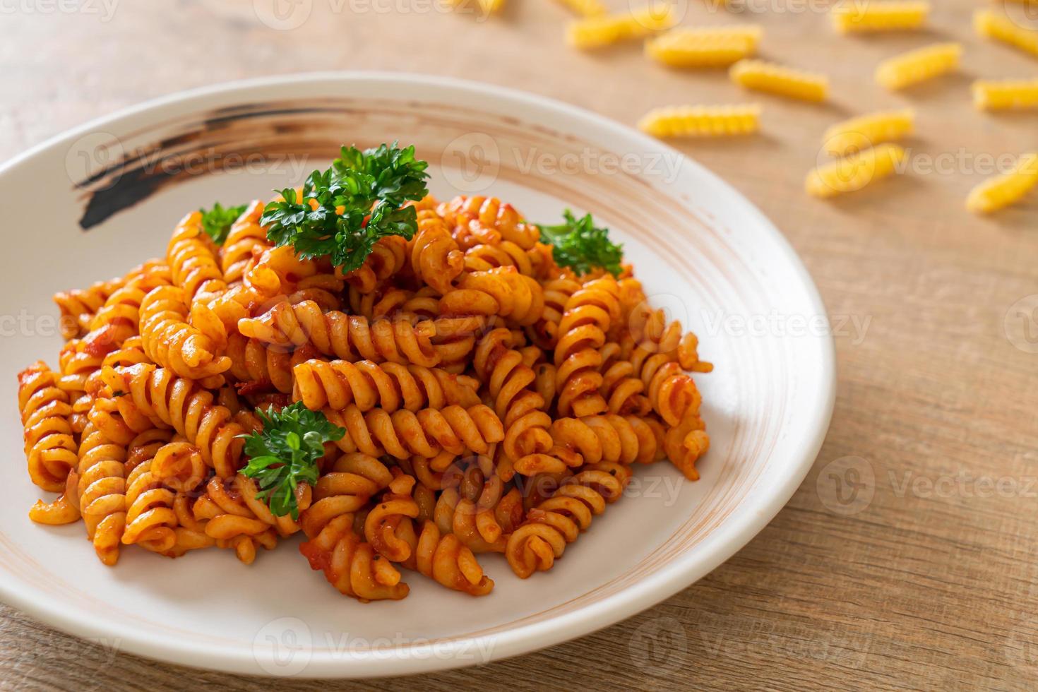 macarrão espiral ou espiral com molho de tomate e salsicha - comida italiana foto