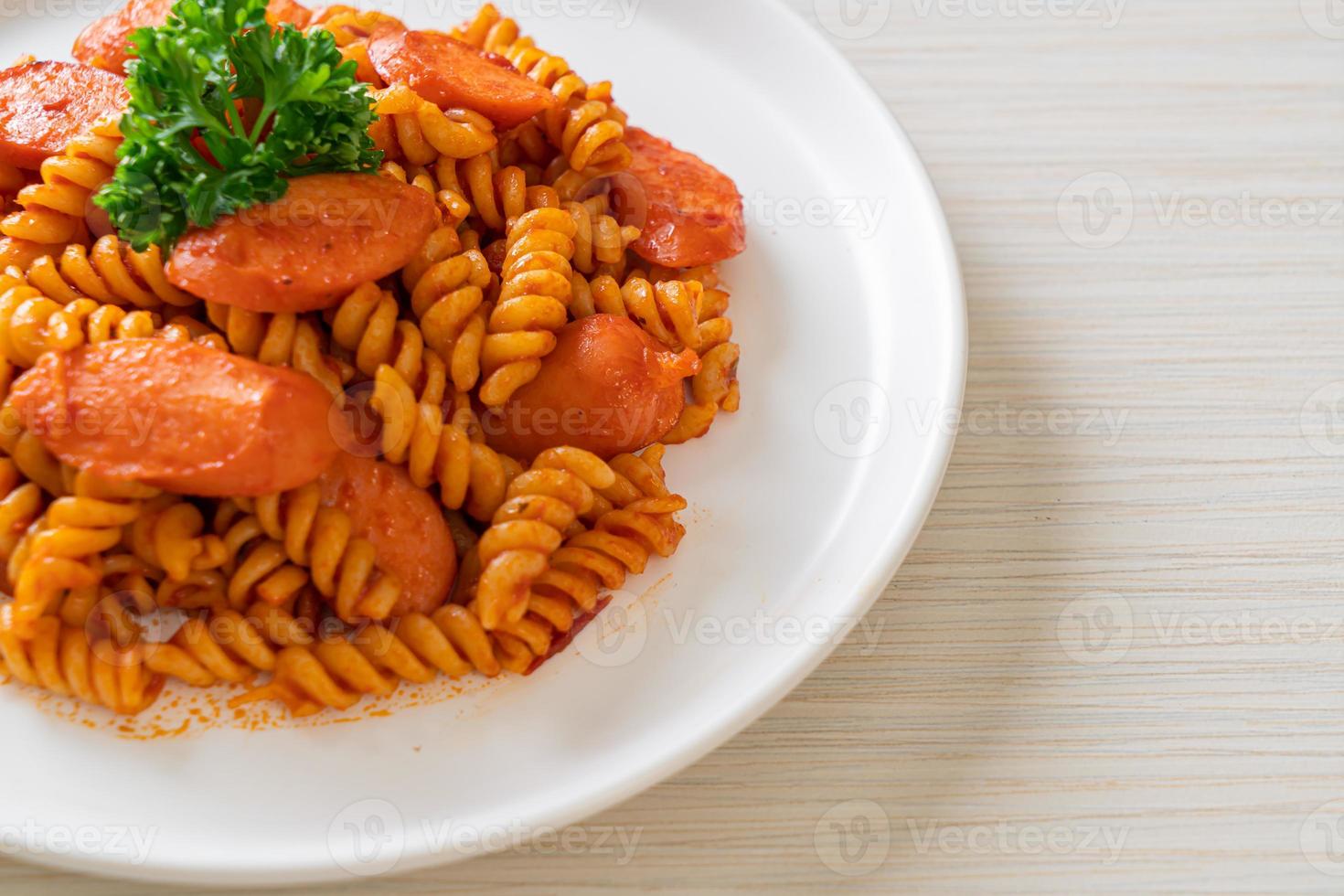 macarrão espiral ou espiral com molho de tomate e salsicha - comida italiana foto