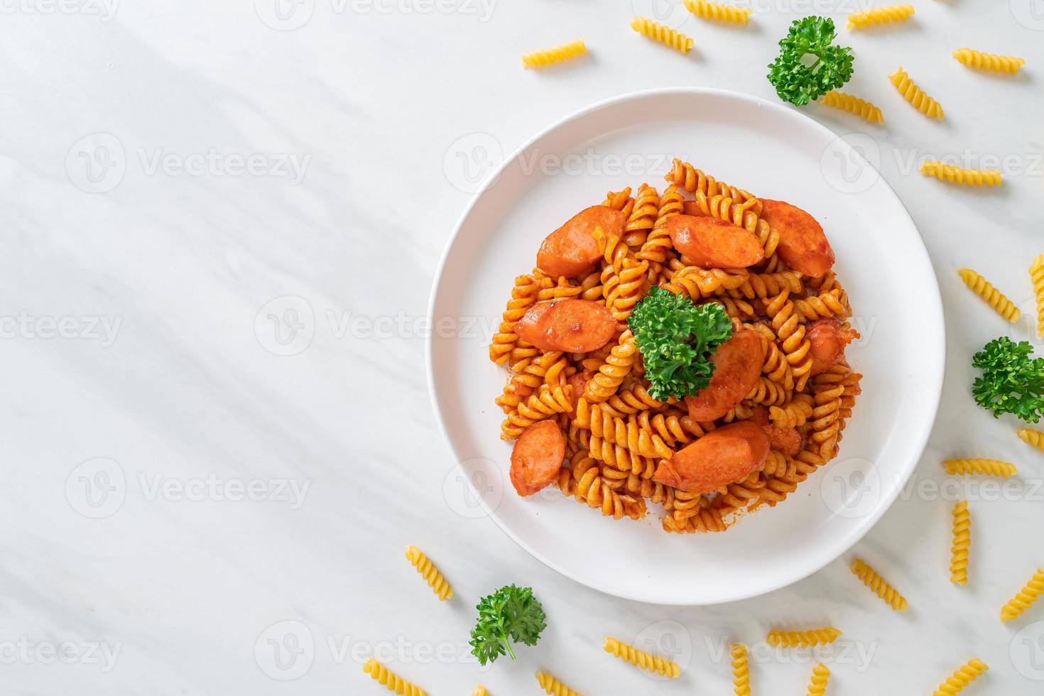 macarrão espiral ou espiral com molho de tomate e salsicha - comida italiana foto