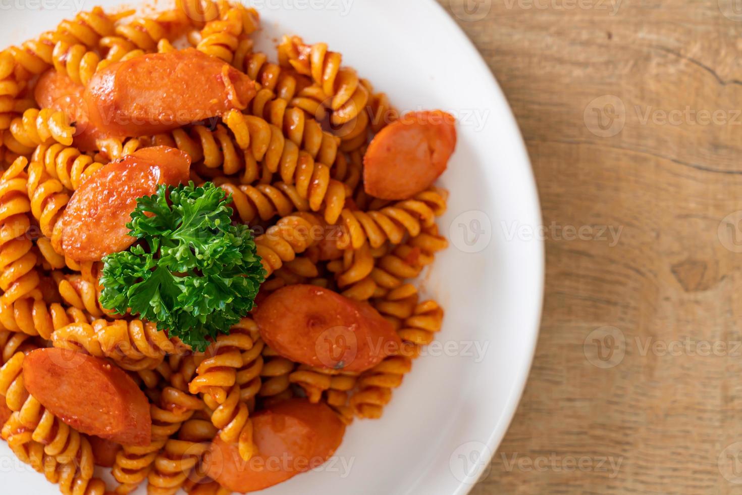 macarrão espiral ou espiral com molho de tomate e salsicha - comida italiana foto