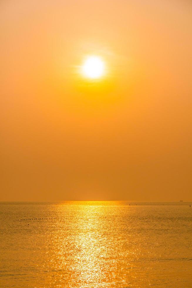 lindo nascer do sol na praia e mar foto