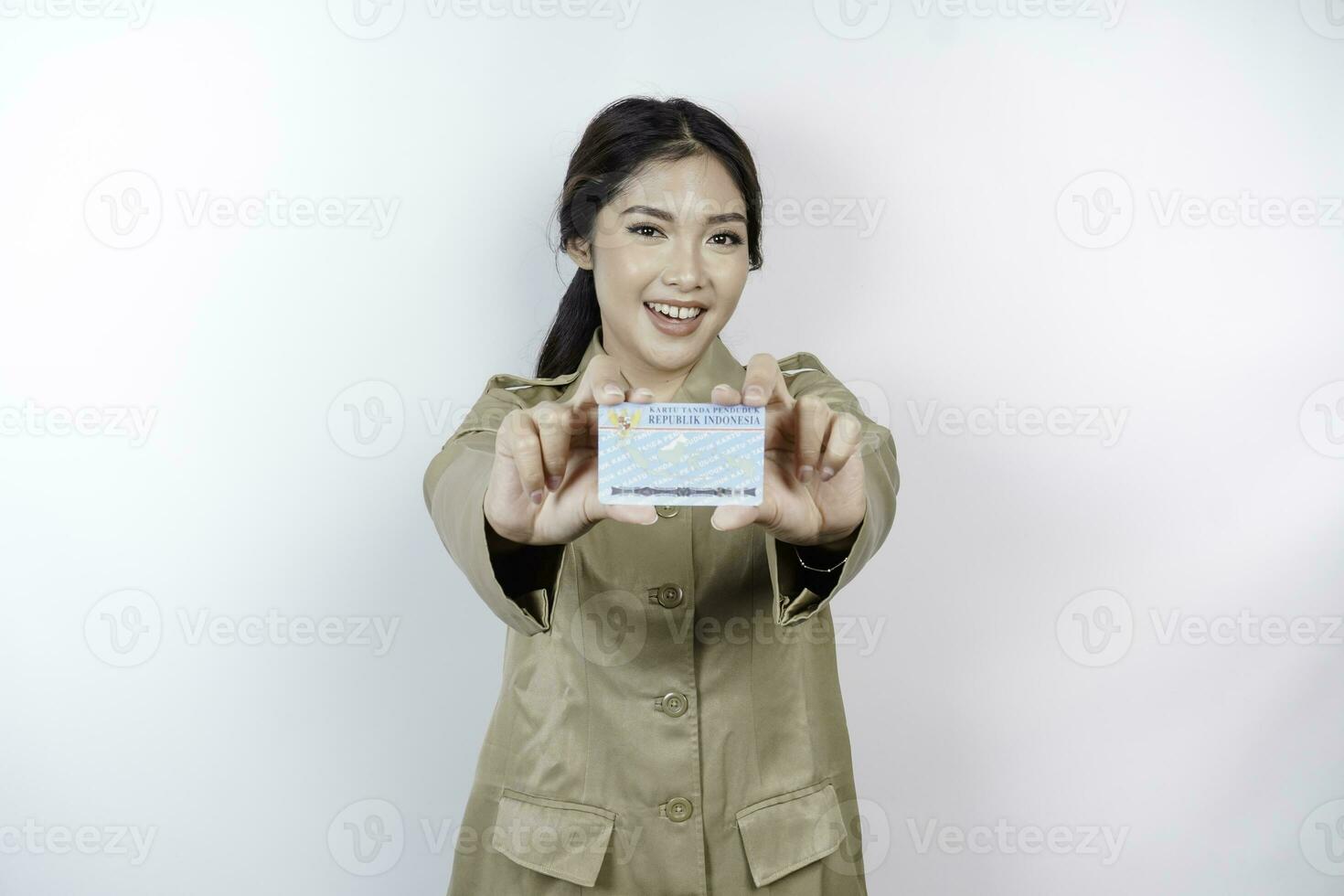 sorridente governo trabalhador mulher segurando indonésio Eu iria cartão. pns vestindo cáqui uniforme. foto