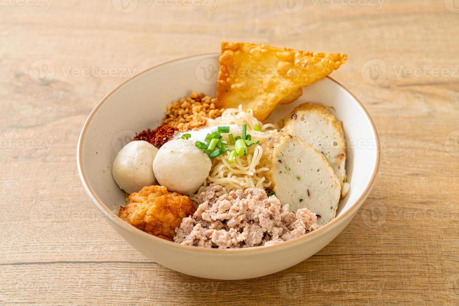 macarrão de ovo picante com bolinho de peixe e bolinho de camarão sem sopa - comida asiática foto