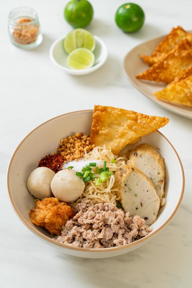 macarrão de ovo picante com bolinho de peixe e bolinho de camarão sem sopa - comida asiática foto