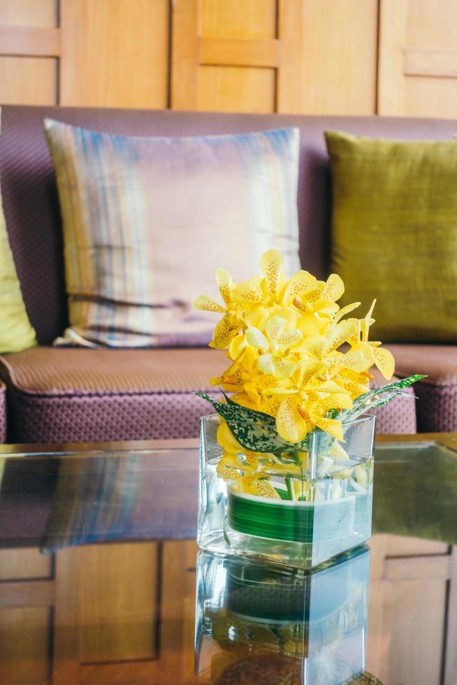 vaso de flores na mesa com almofada no sofá foto