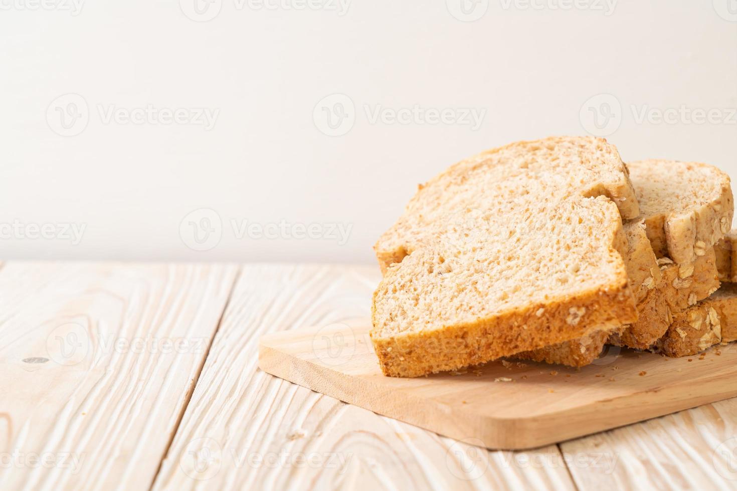 pão integral fatiado em uma mesa de madeira foto
