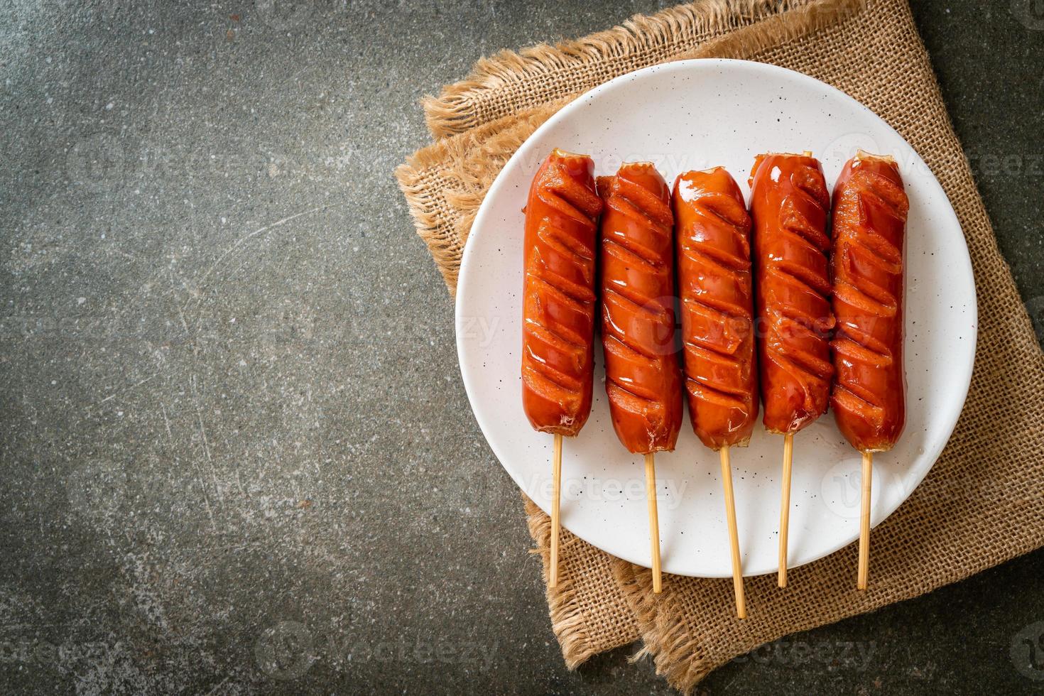 espeto de linguiça frita em prato branco foto