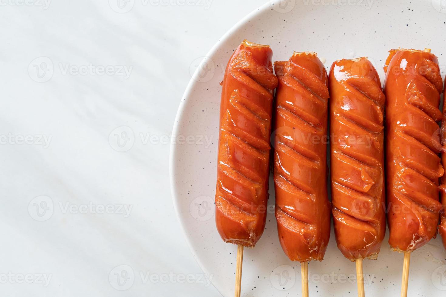 espeto de linguiça frita em prato branco foto