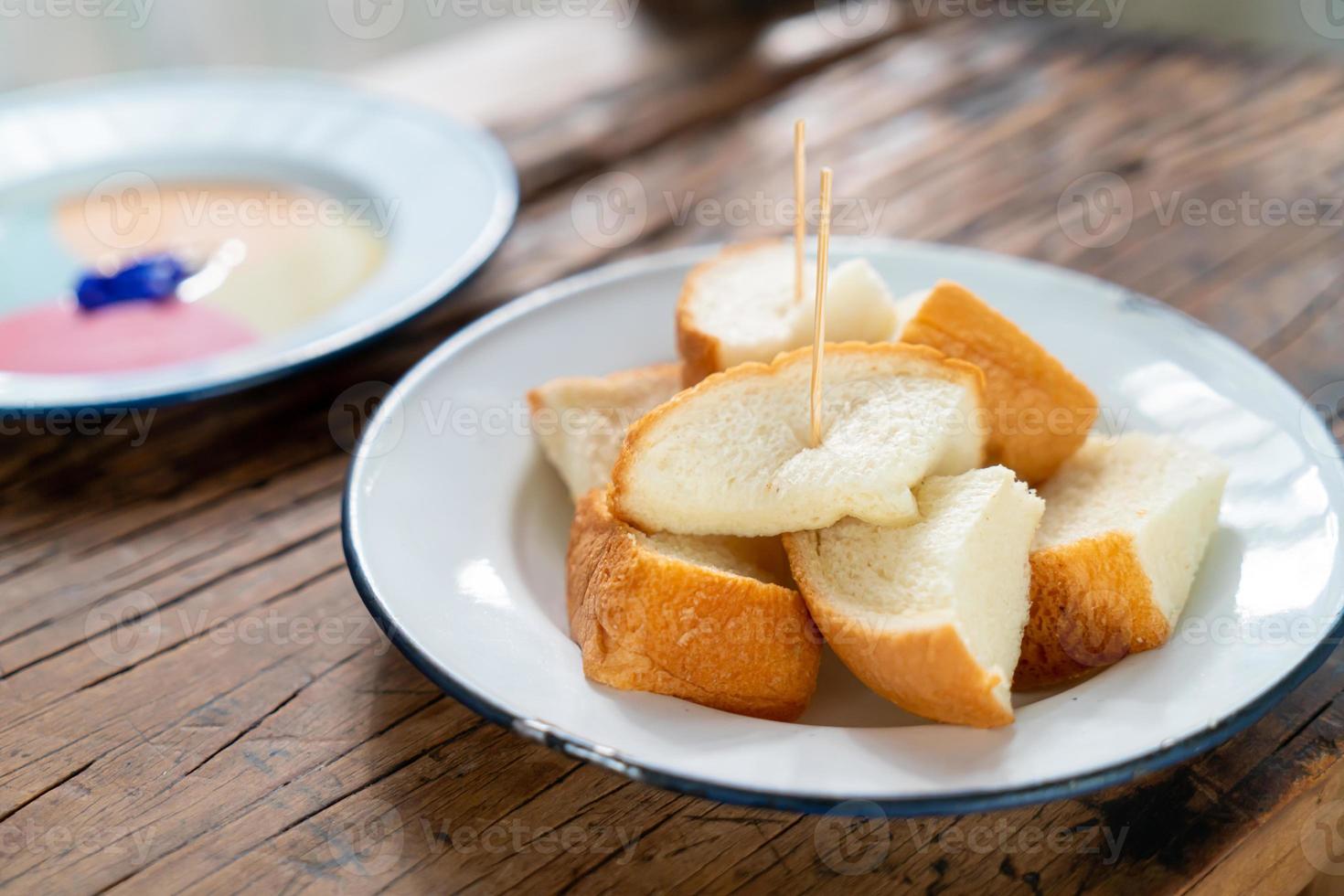 Pão torrado no vapor com creme colorido sobre fundo de madeira foto