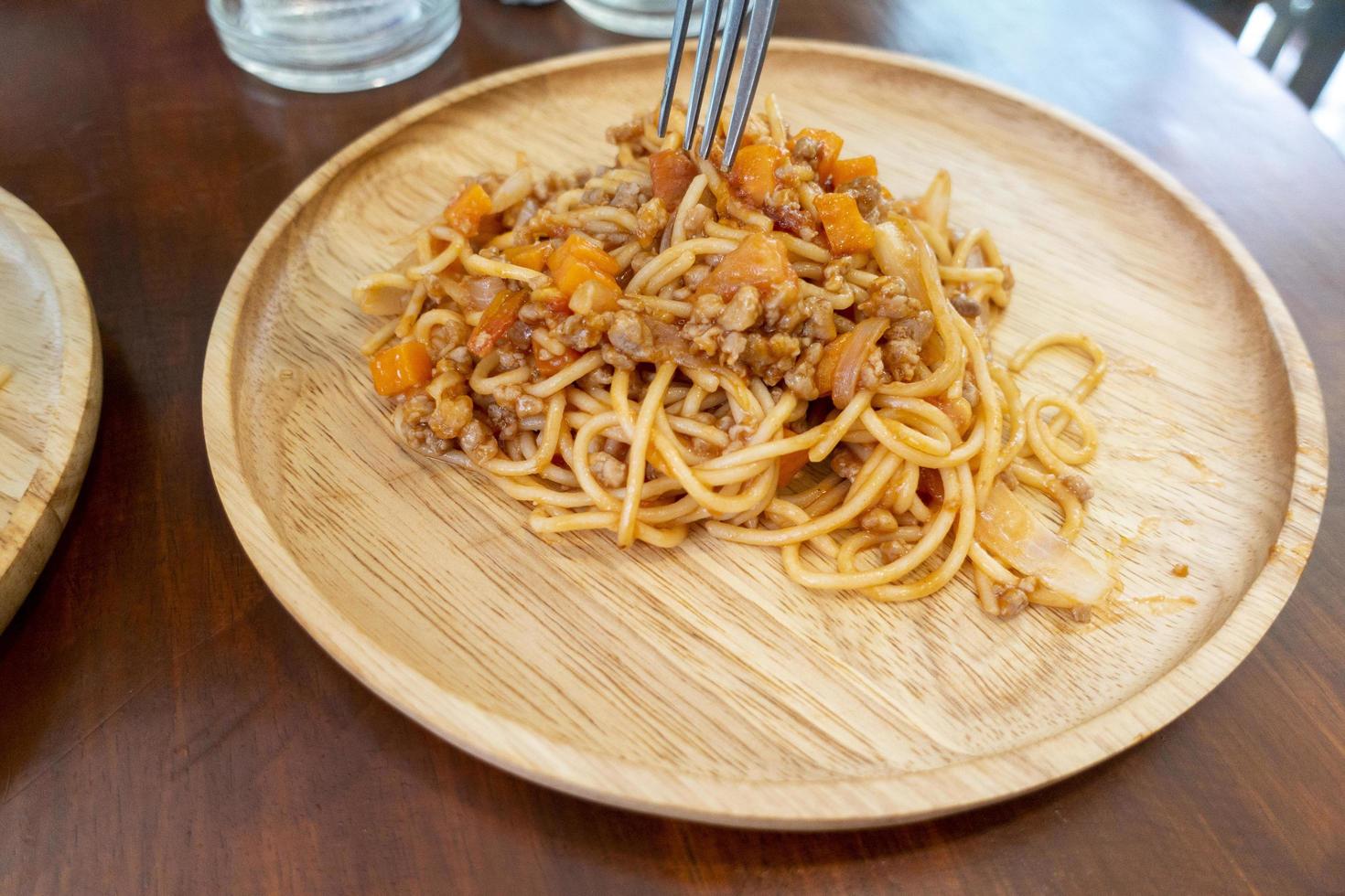 close-up de espaguete no prato de madeira foto