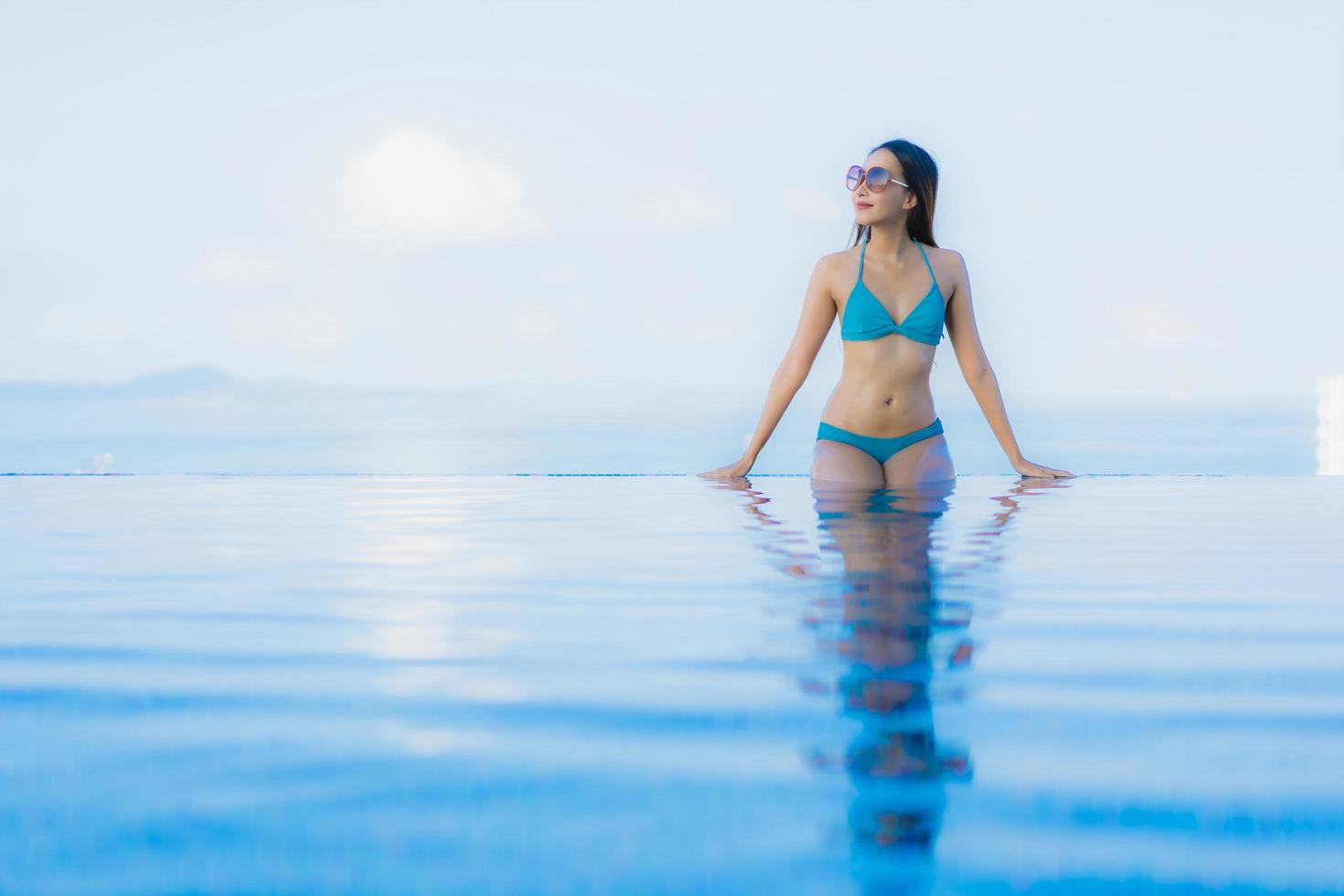 retrato lindas jovens mulheres asiáticas sorriso feliz relaxe piscina ao ar livre no resort foto