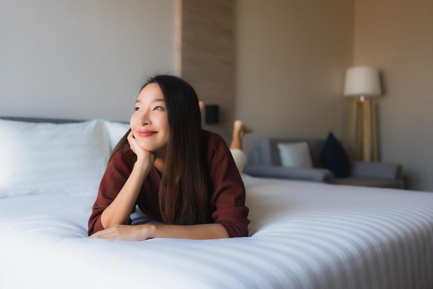 retrato de belas jovens mulheres asiáticas feliz sorriso relaxe na cama foto