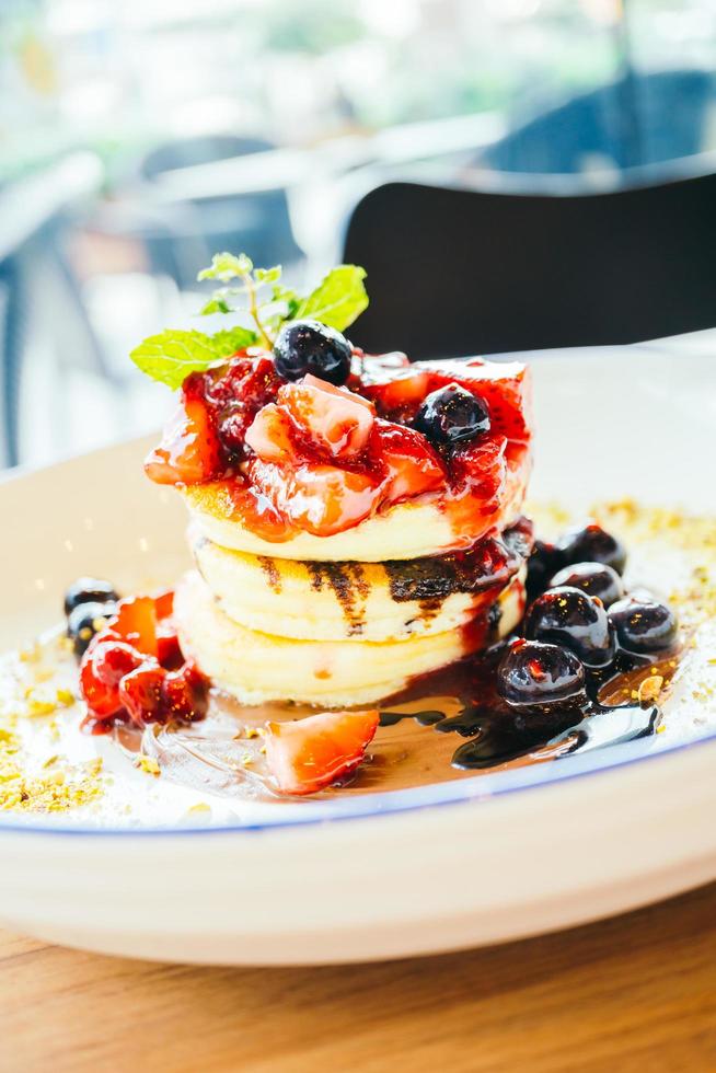 panquecas com frutas vermelhas misturadas em prato branco foto