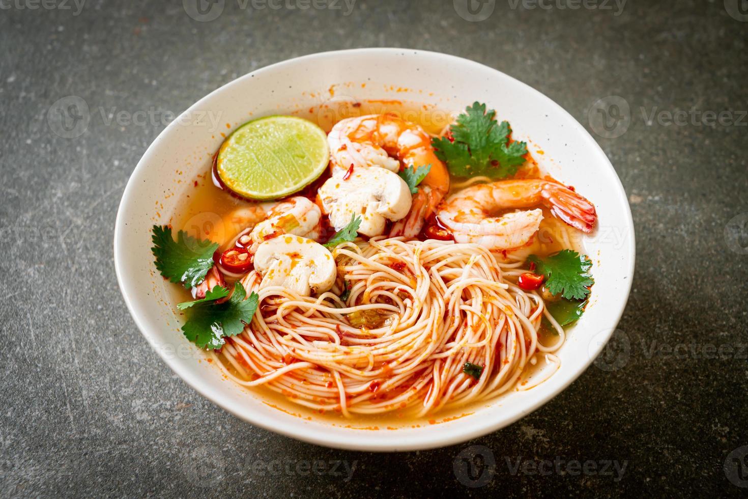 macarrão com sopa picante e camarão em tigela branca ou tom yum kung - comida asiática foto
