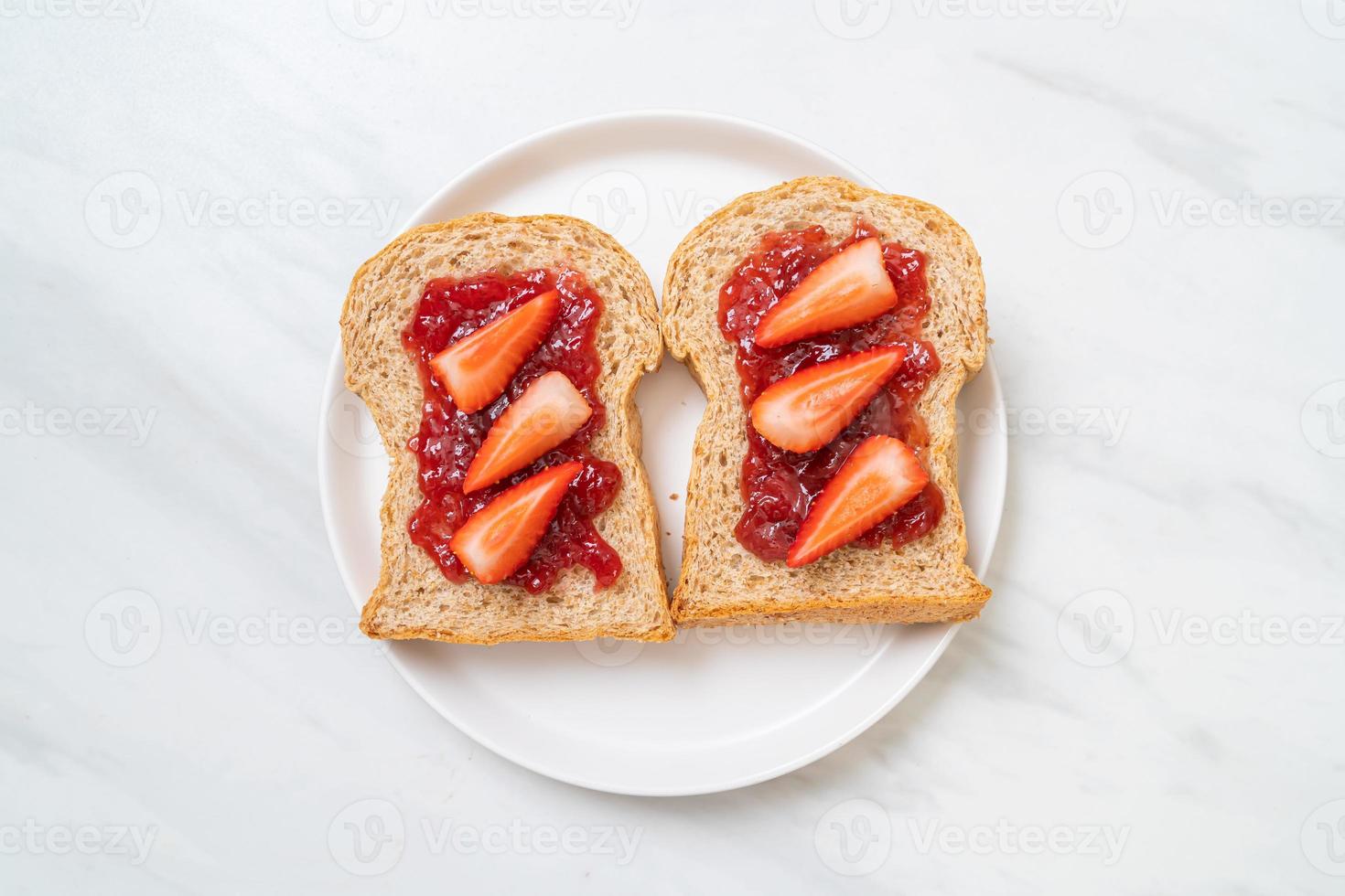 pão integral caseiro com geléia de morango e morango fresco foto