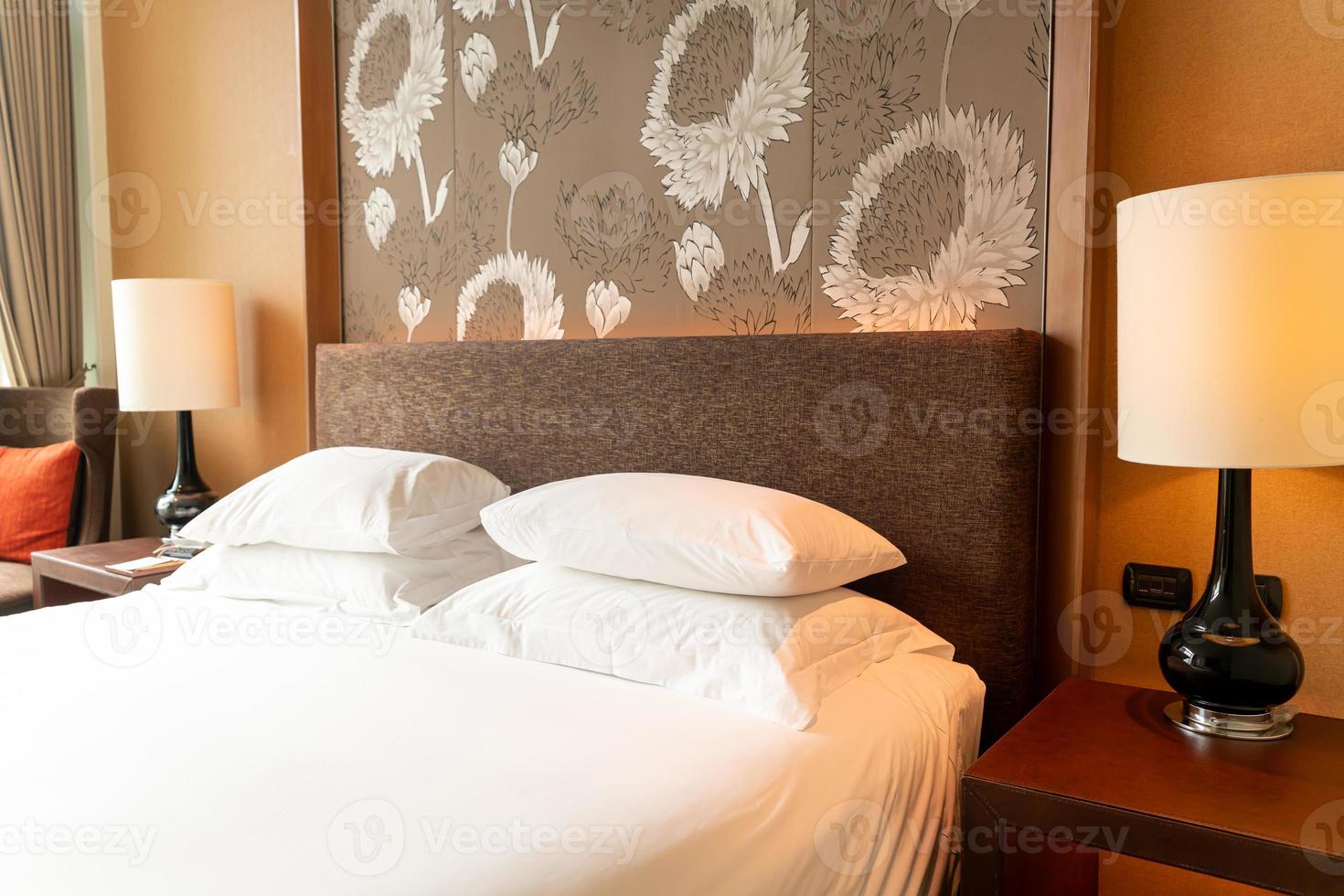 decoração de travesseiro branco na cama no quarto do hotel resort foto