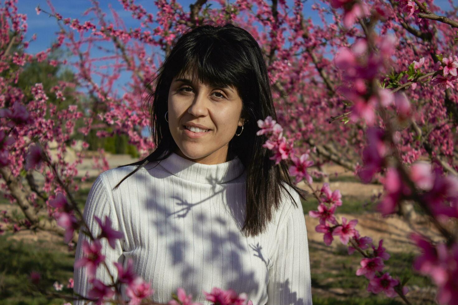 mulher entre a bonita Rosa pêssego árvore flores foto