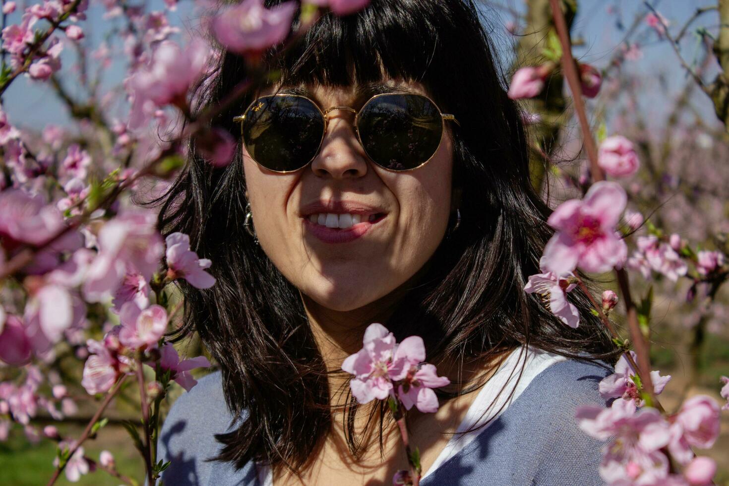 mulher entre a bonita Rosa pêssego árvore flores foto