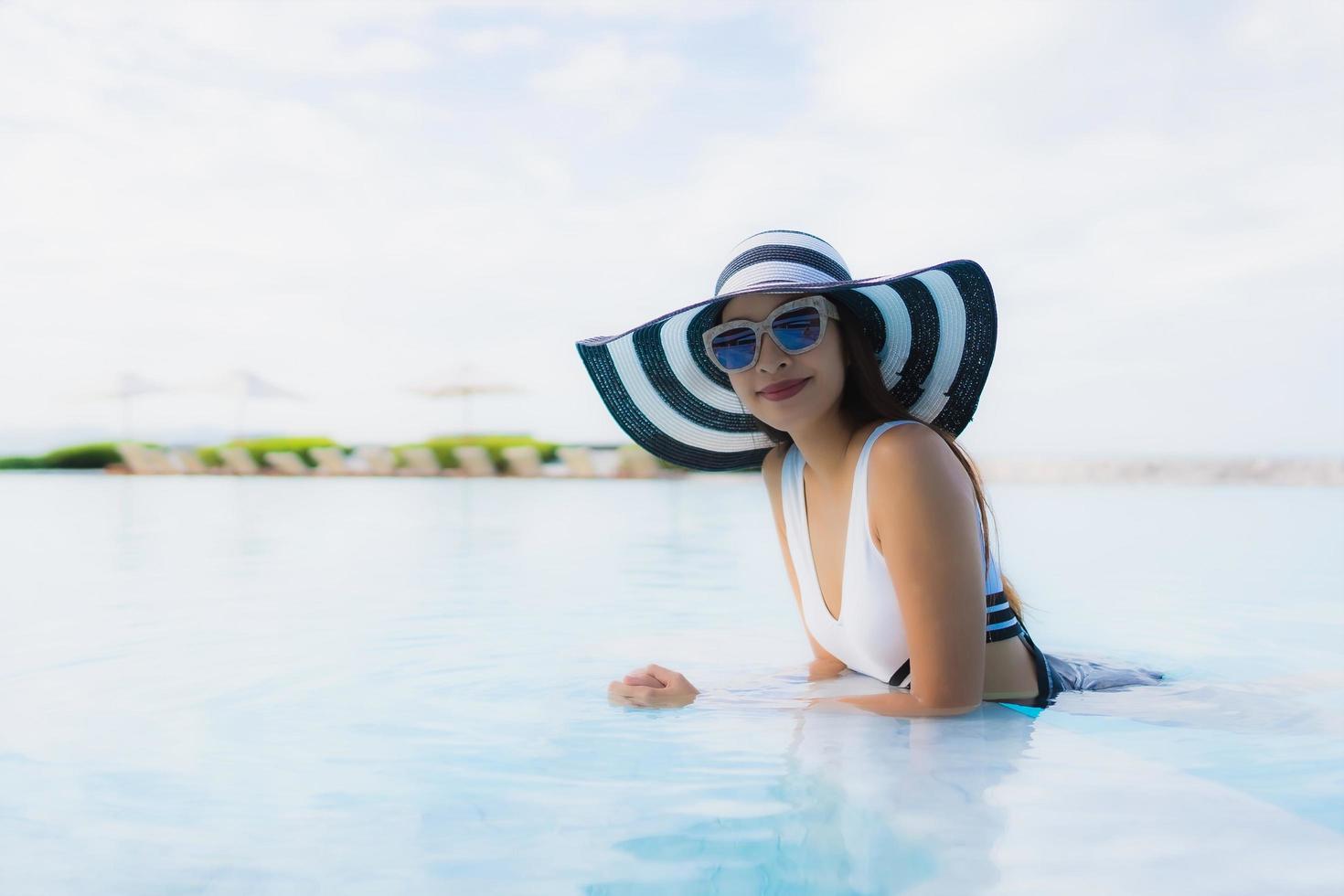 retrato lindas jovens mulheres asiáticas sorrindo feliz relaxando na piscina foto