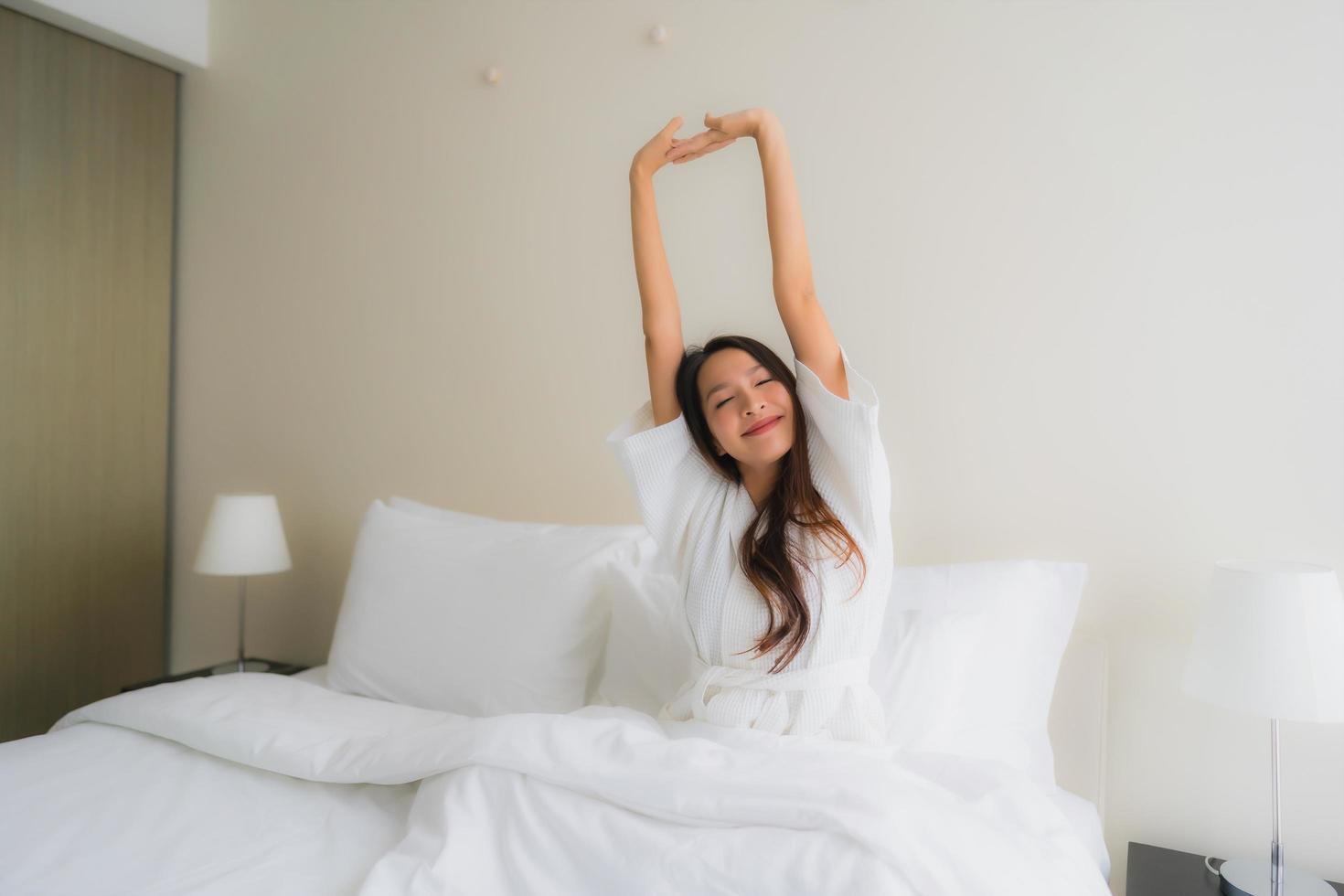 retrato de belas jovens mulheres asiáticas sorrindo feliz na cama foto