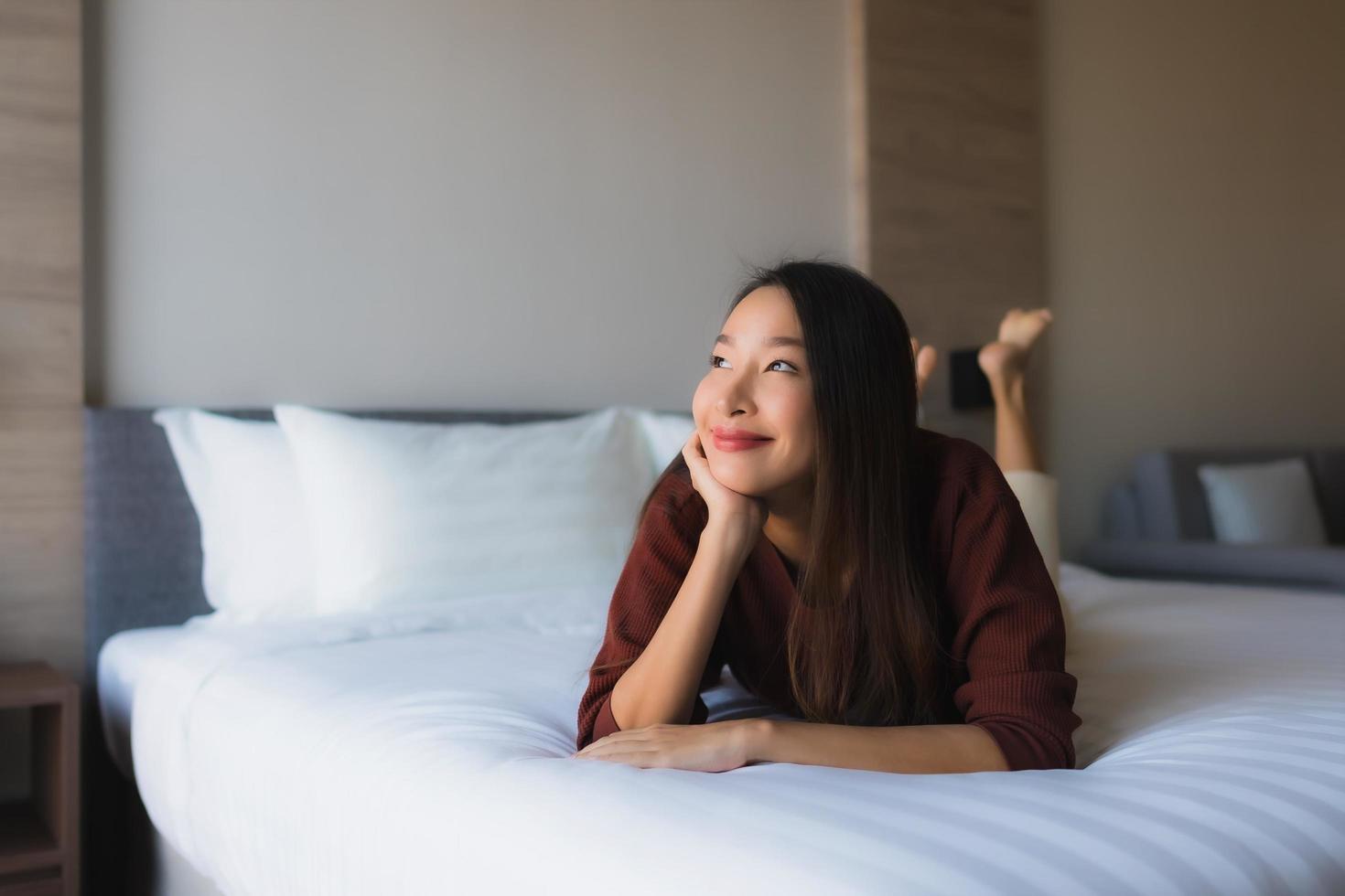 retrato de belas jovens mulheres asiáticas feliz sorriso relaxe na cama foto