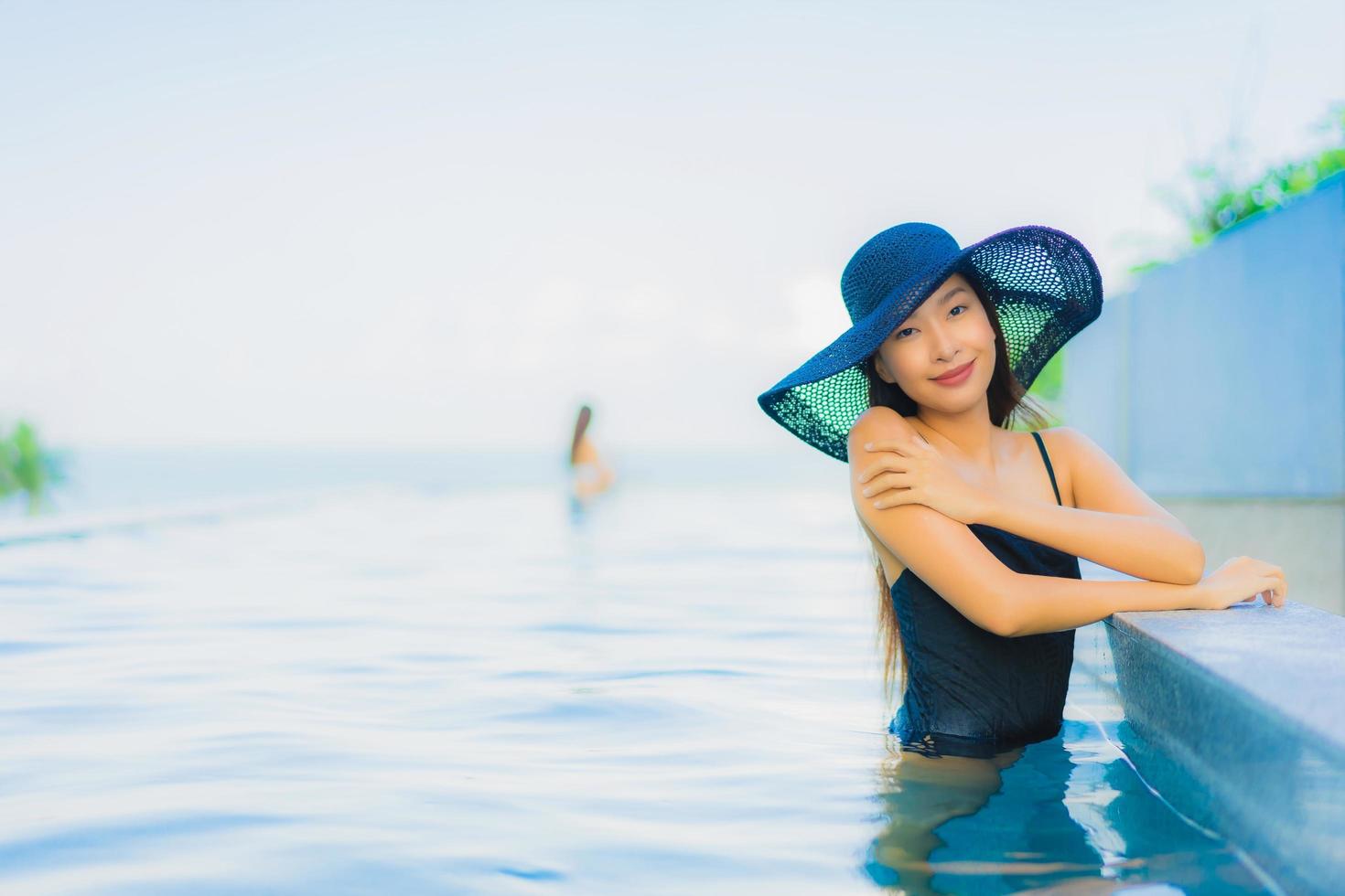 retrato lindas jovens mulheres asiáticas sorriso feliz relaxe piscina ao ar livre no hotel foto