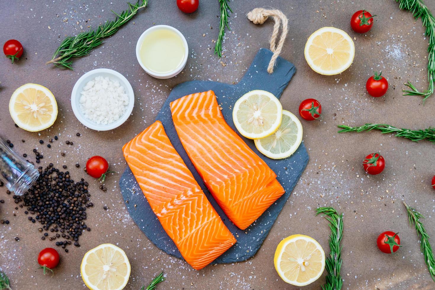 Filé de carne de salmão crua e fresca em ardósia preta foto